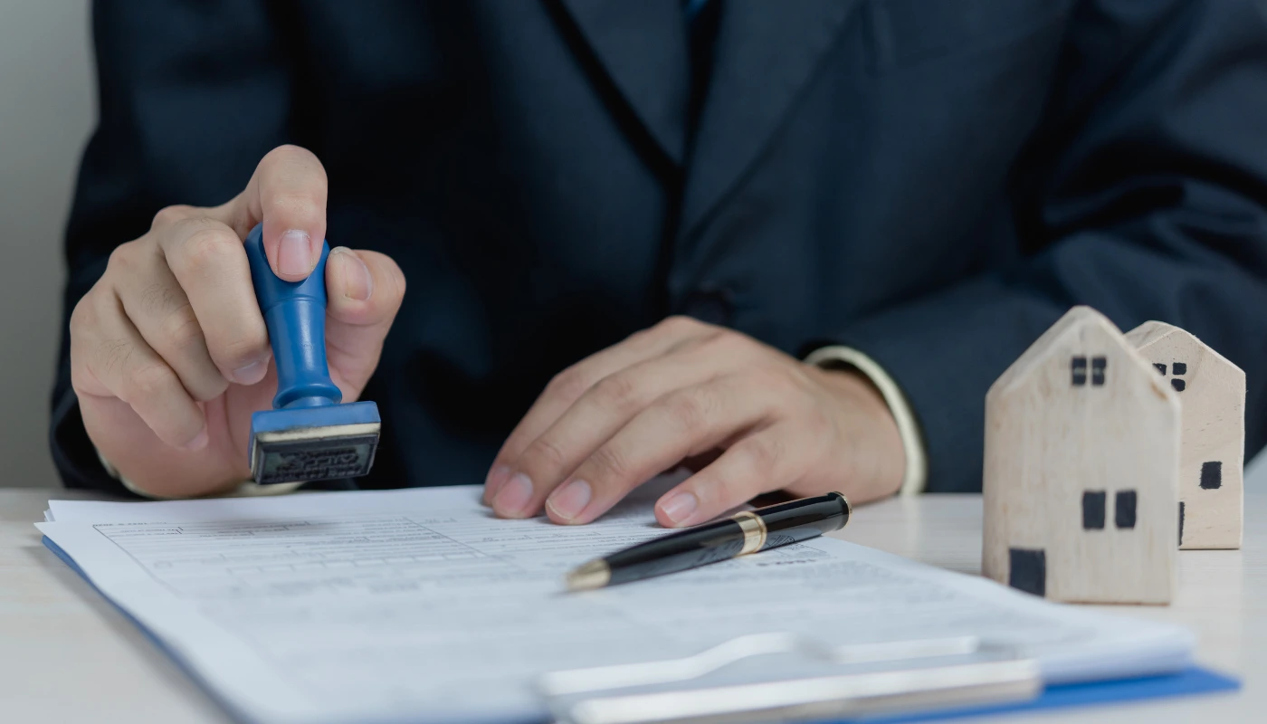 Home loan approval process showing mortgage documents, property paperwork, and house models during loan verification.